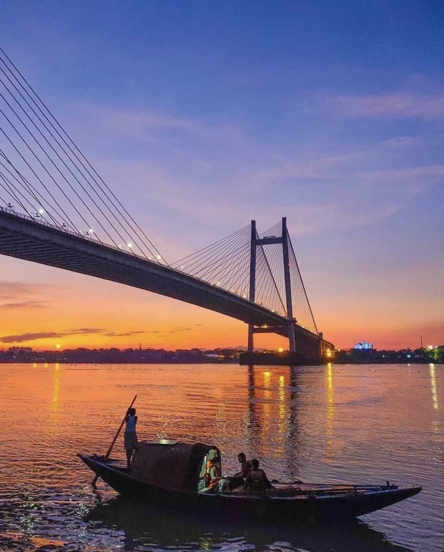 A boat on the Yamuna beneath the New Yamuna Bridge at sunset